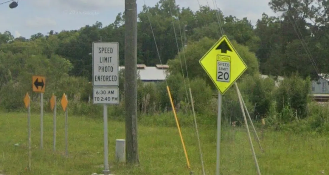 Speed Limit Photo Enforced 6:30 AM to 2:40 PM sign next to School Speed Limit 20 ahead warning in Lawtey